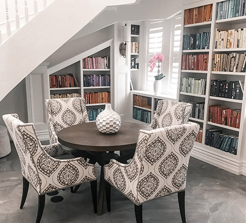 Table infront of a bookshelf with color coded and beautifully organized books